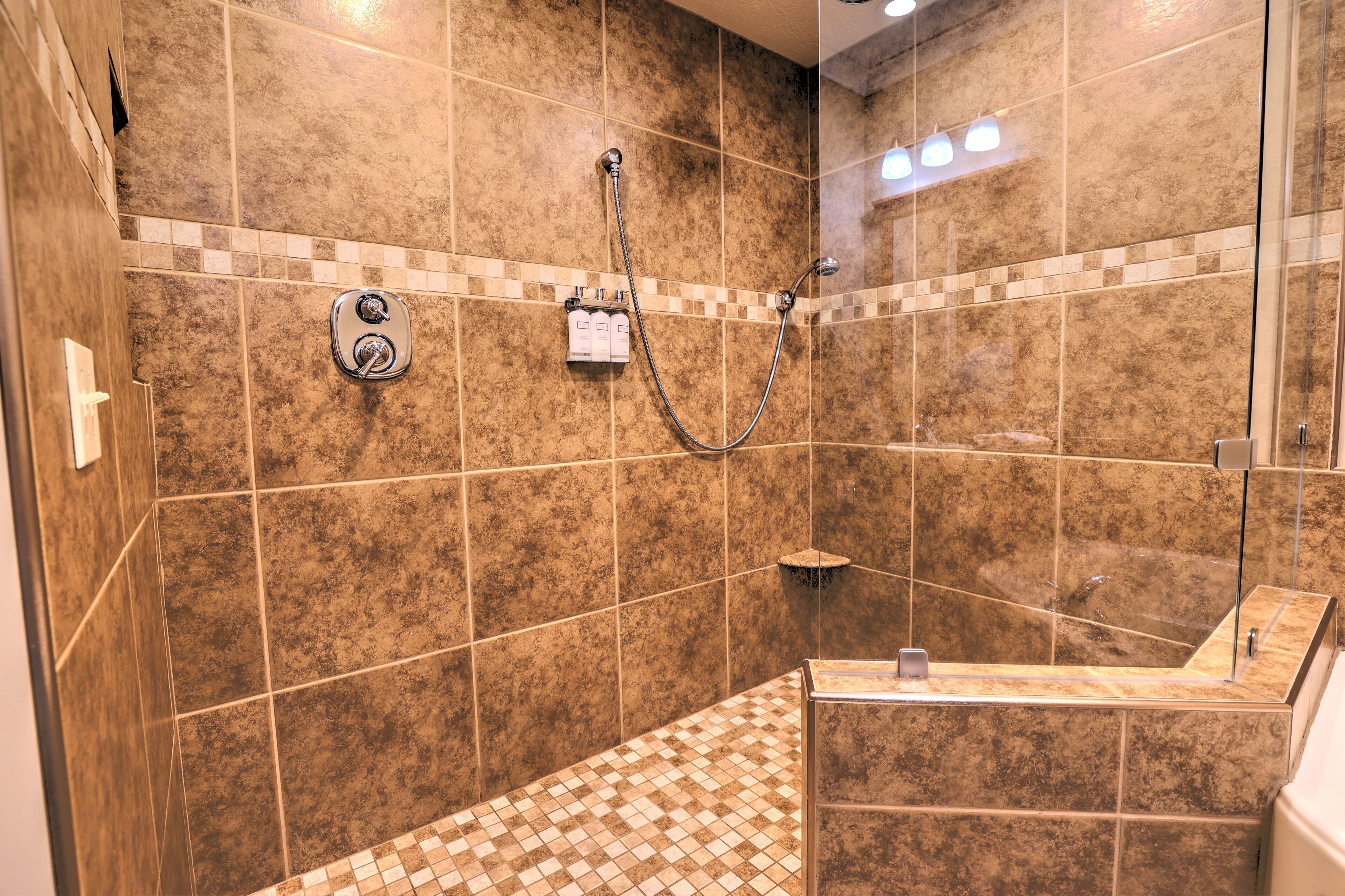A modern bathroom with a shower, a bathtub, and a tiled floor.