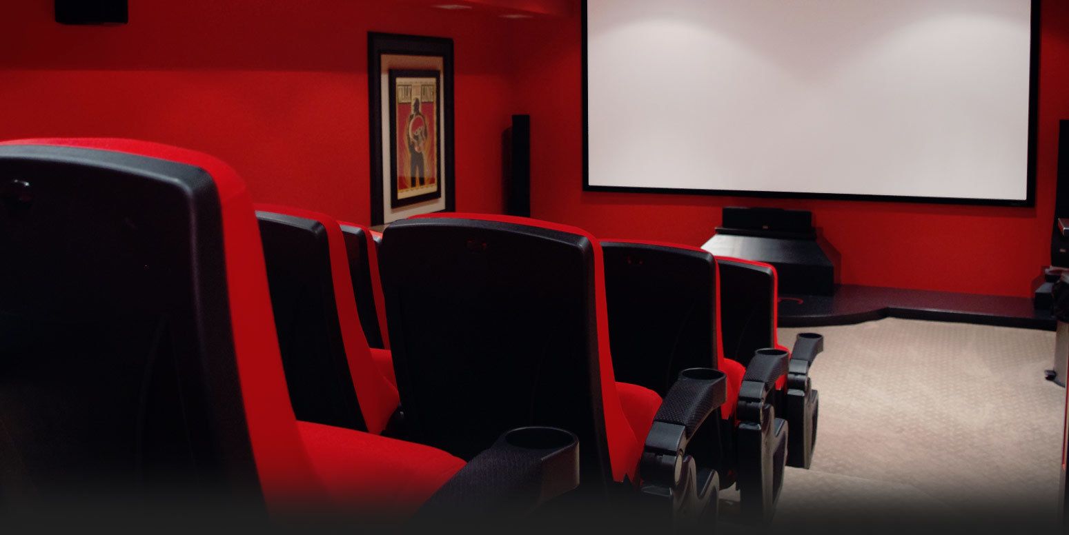 Un cine con butacas rojas y una pantalla grande.