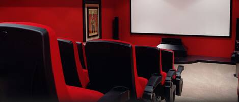 Un cine con butacas rojas y una pantalla grande.