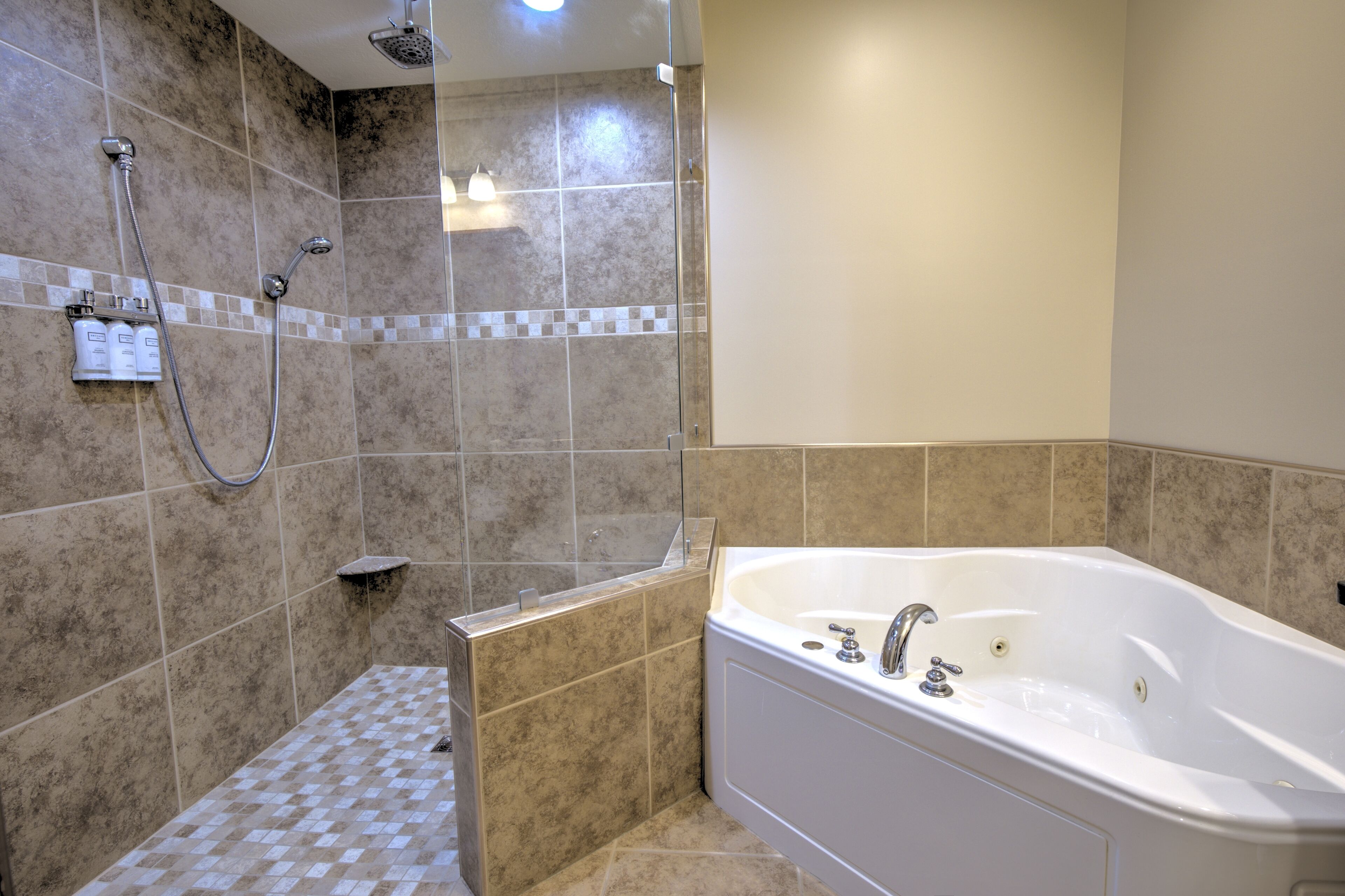 Un baño con bañera, ducha y suelo de baldosas.