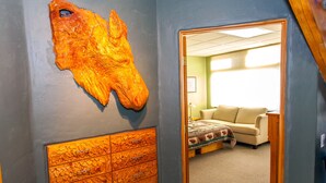 A room with a large wooden cabinet and a mounted animal head sculpture.