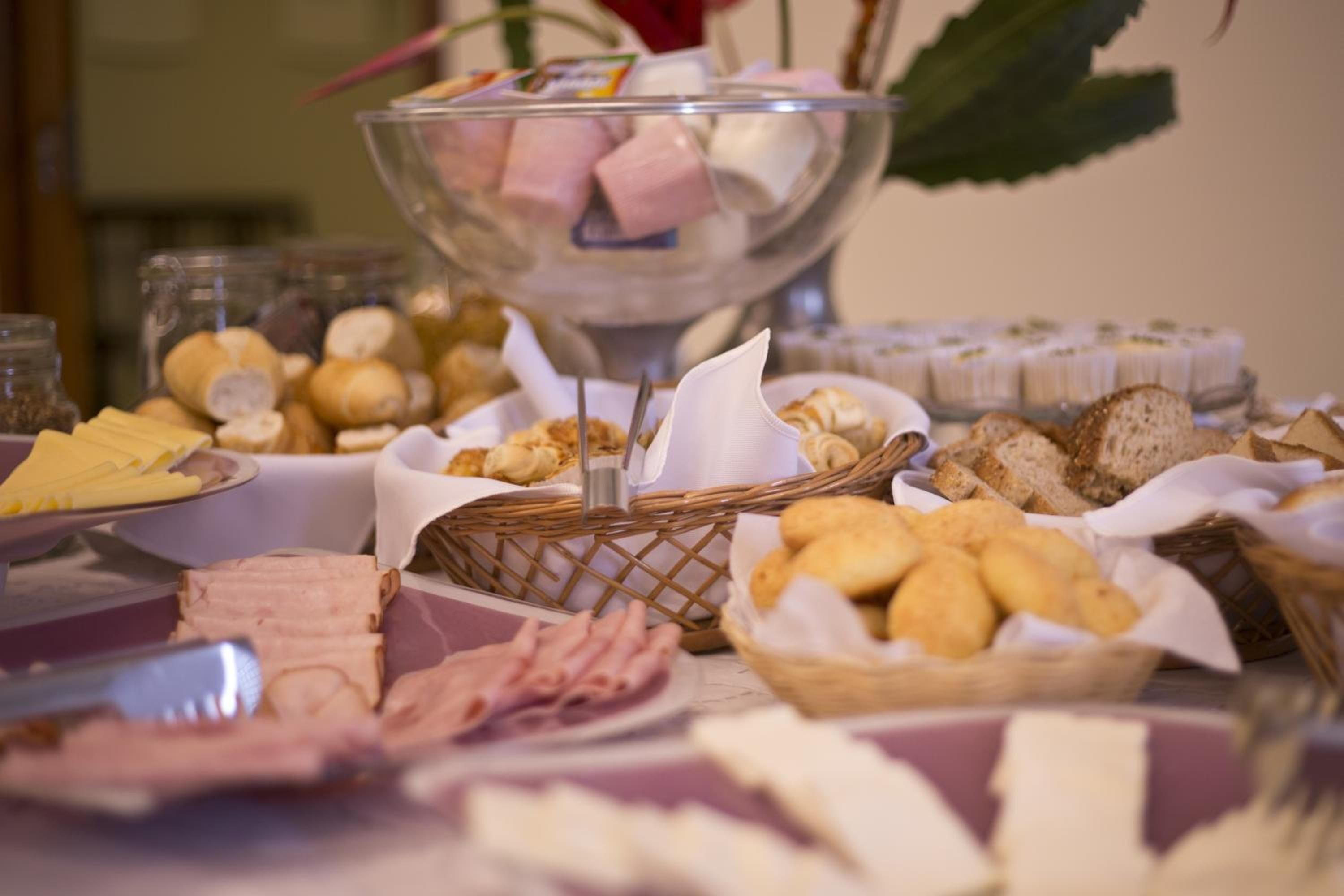 Een buffet met diverse soorten eten, zoals kazen, vleeswaren en brood.
