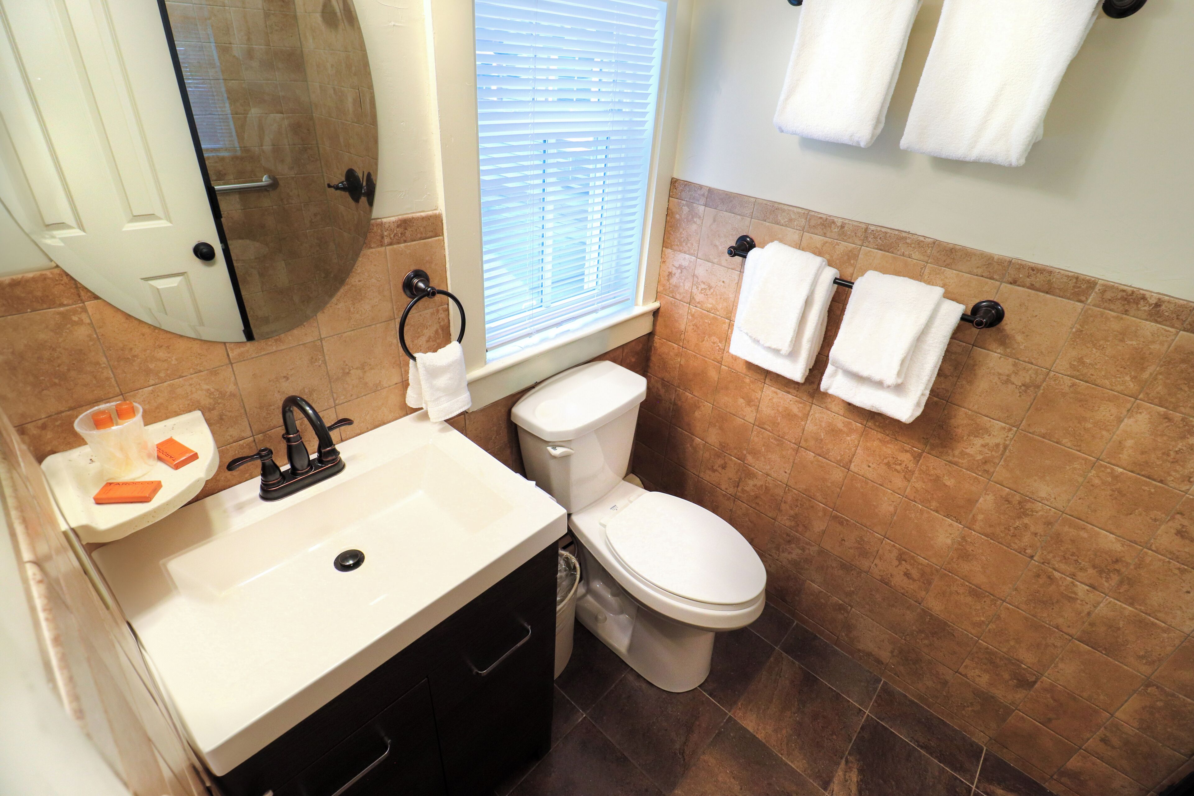 A bathroom with a sink, toilet, and towel rack.