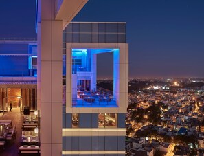 A modern hotel with a rooftop dining area and a panoramic city view. - ARTEZIA (Bengaluru)