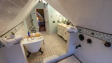 A bathroom with a bathtub, a vanity with a sink, and a shower area.