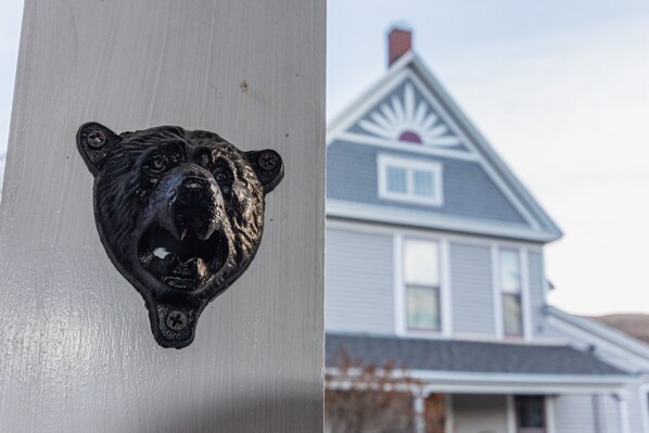 Una casa con techo a dos aguas y una cabeza de oso decorativa en la puerta principal.