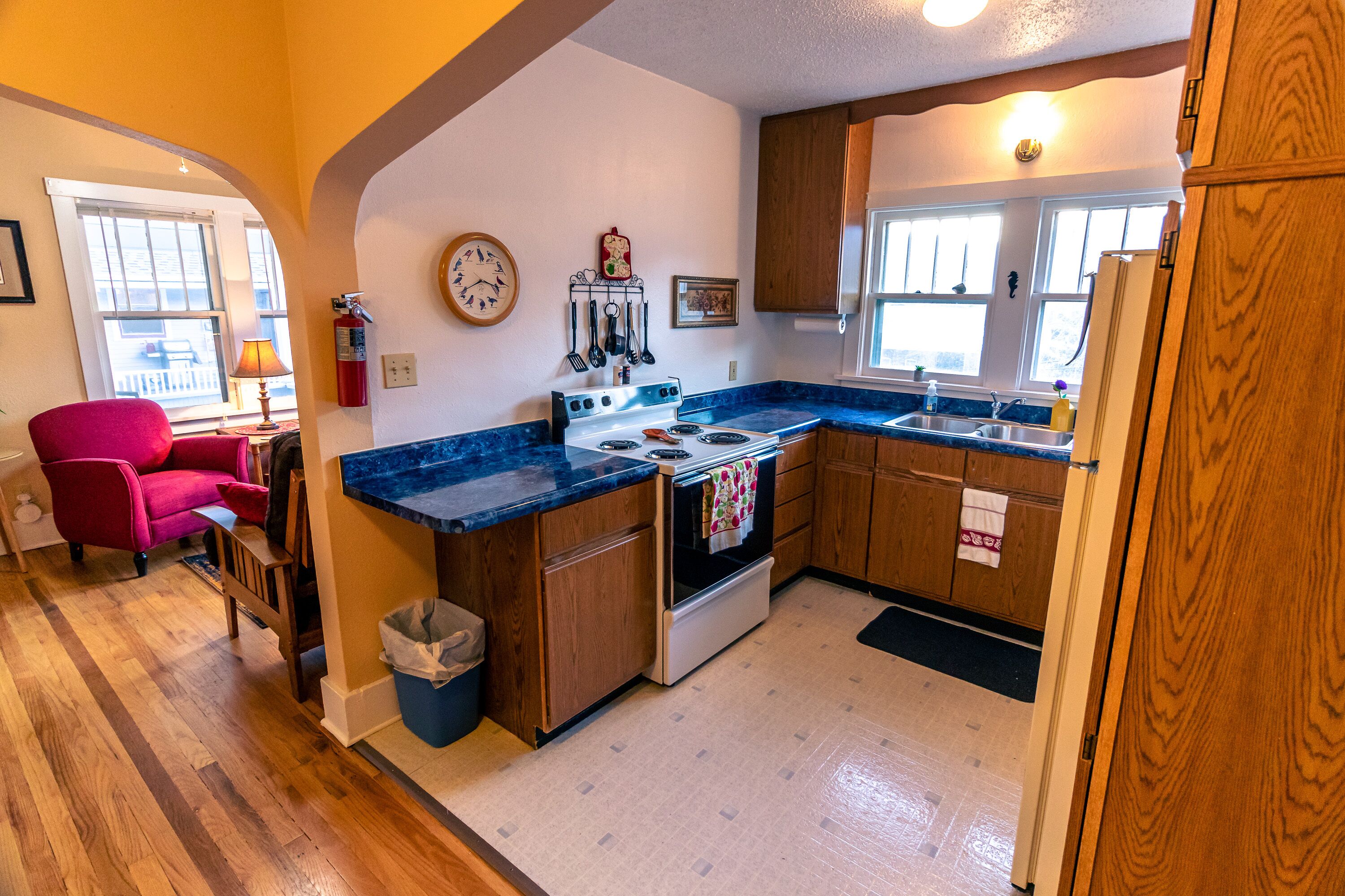 A kitchen with wooden cabinets, a stove, and a sink.