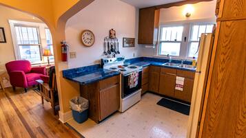 A kitchen with wooden cabinets, a stove, and a sink.