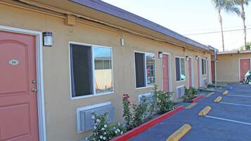 A motel with a row of rooms, each with a window and a door.