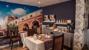A restaurant with tables set for dining, a coffee station, and a mural of a building on the wall. - Los Leones Hotel Boutique (Arequipa)