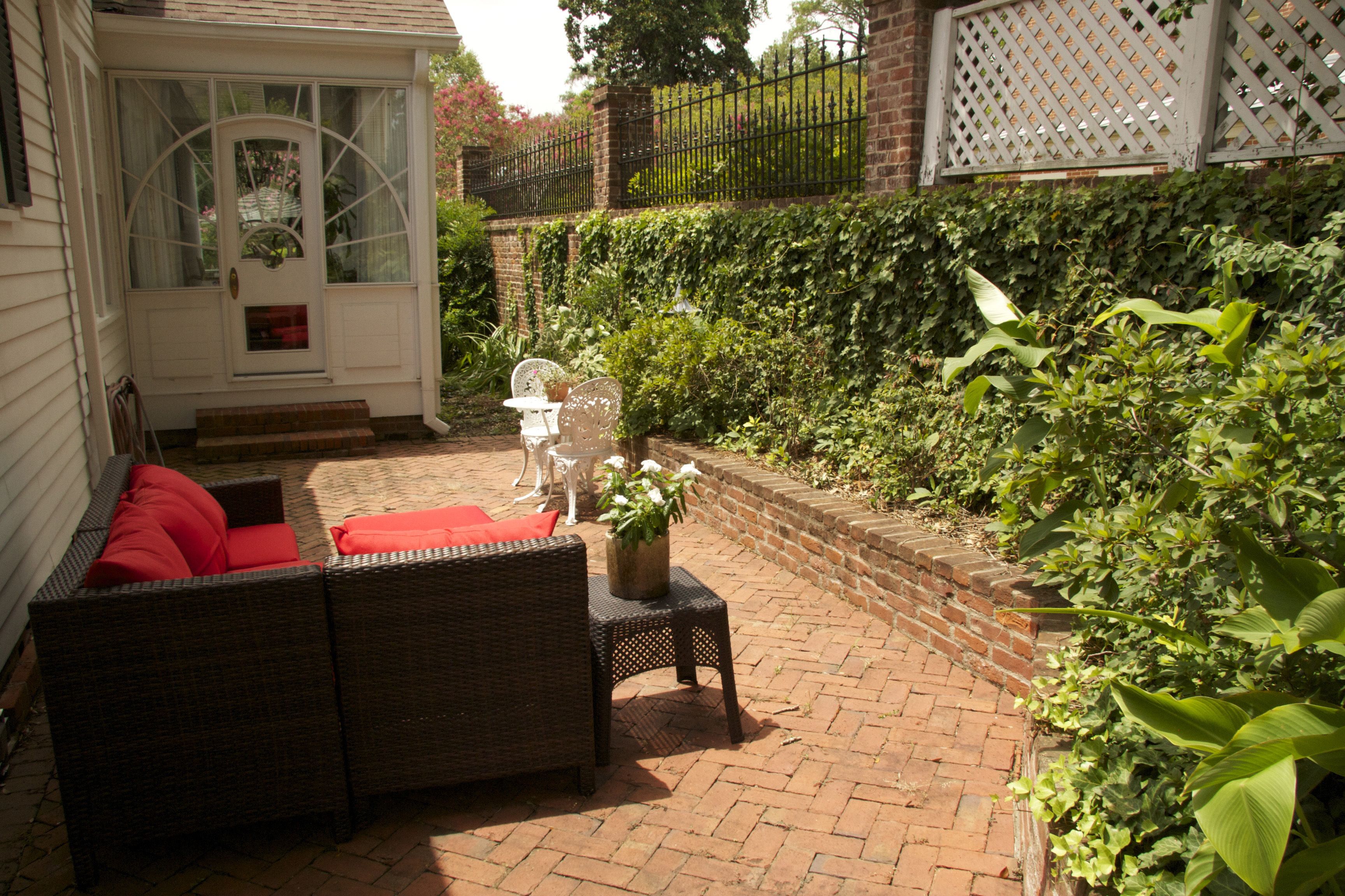 A patio with wicker furniture and a white door.