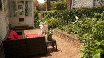 A patio with wicker furniture and a white door.