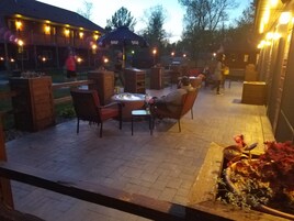 Un espacio al aire libre con jacuzzi, asientos y un hogar para fuego.