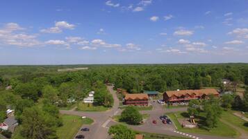 An aerial view of a resort with multiple buildings, a parking area, and surrounding greenery.