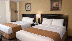 Two double beds with headboards, a bedside table with a lamp, and a framed picture on the wall. - Travelodge by Wyndham Valleyview AB (Valleyview)