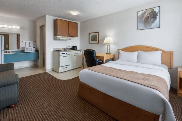 A hotel room with a bed, a desk, a chair, a kitchenette, and a bathroom. - Travelodge by Wyndham Valleyview AB (Valleyview)