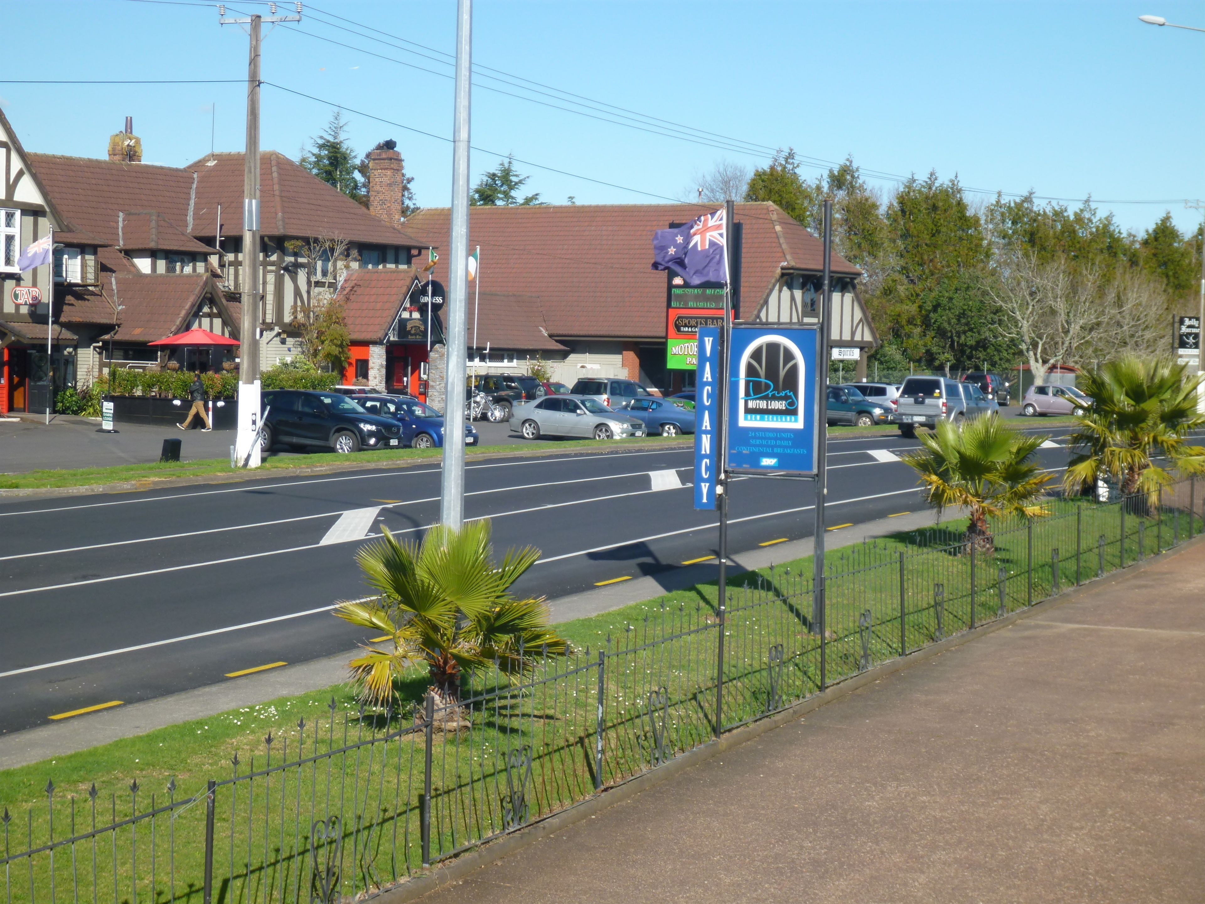 Une vue de rue avec un panneau bleu indiquant la présence d’un motel.