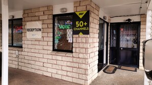 Un espace d’accueil avec un panneau indiquant plus de 50 chaînes et un autre panneau indiquant « réception ».