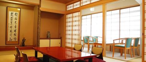 Una habitación japonesa tradicional con suelo de tatami, una mesa baja y sillas.