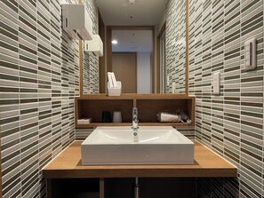 A modern bathroom with a rectangular sink, wooden countertop, and a mirror above it. - Arima Gyoen (Kobe)