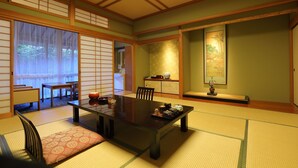 Ein traditioneller japanischer Raum mit Tatami-Böden, einem niedrigen Tisch und Schiebetüren.
