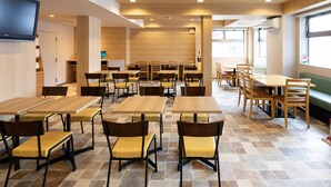 A modern dining area with multiple tables and chairs, wooden flooring, and large windows allowing natural light. - Comfort Inn Kofu Showa Inter (Kofu)