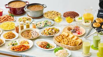 Una mesa con diferentes platos, como pasta, sopa y gofres.