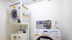 A laundry facility with two washing machines, one with a control panel and the other with a digital display. - Comfort Inn Kofu Showa Inter (Kofu)