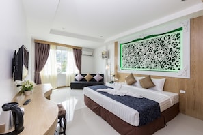 Une chambre d’hôtel moderne comprenant un lit, un bureau avec une chaise, un canapé et un grand élément décoratif mural.