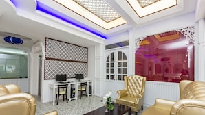 A modern living room with a white and gold color scheme, featuring a sofa, armchairs, a coffee table, and a desk with a computer. - Triple Three Patong (Patong)