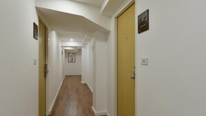 A narrow hallway with wooden flooring, white walls, and doors on both sides. - iCheck inn Sukhumvit 19 (Bangkok)
