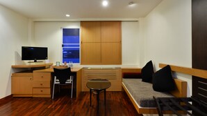 A compact room with a bed, a desk, a chair, and a TV. - iCheck inn Sukhumvit 19 (Bangkok)