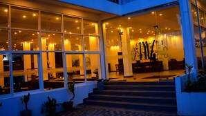 A modern hotel lobby with large windows, a staircase, and indoor plants. - Sole Luna Resort & Spa (Tangalle)