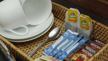 A wicker basket containing various coffee and tea products, including Nescafé Classic and Nestea, along with a spoon and white cups.