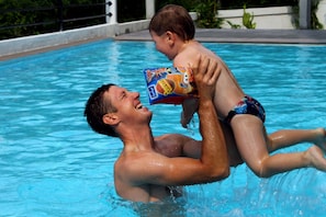 Un hombre y un niño en una piscina.