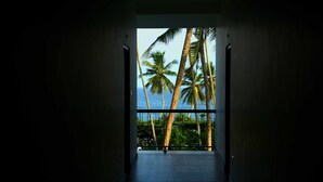 A hallway leading to a balcony with a view of palm trees and the ocean. - Sole Luna Resort & Spa (Tangalle)