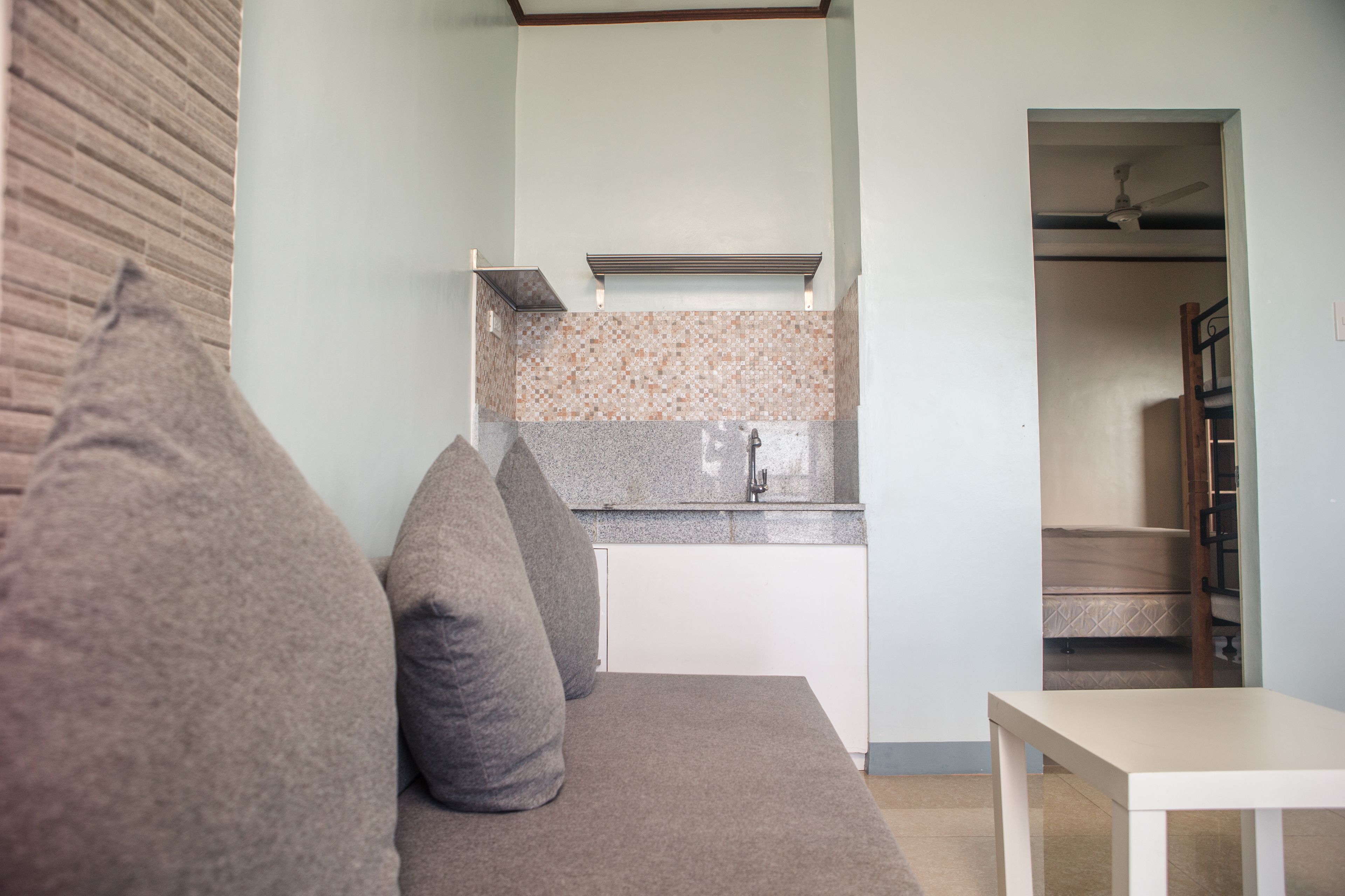 Una cocina moderna con encimera de granito, horno empotrado y mueble blanco.