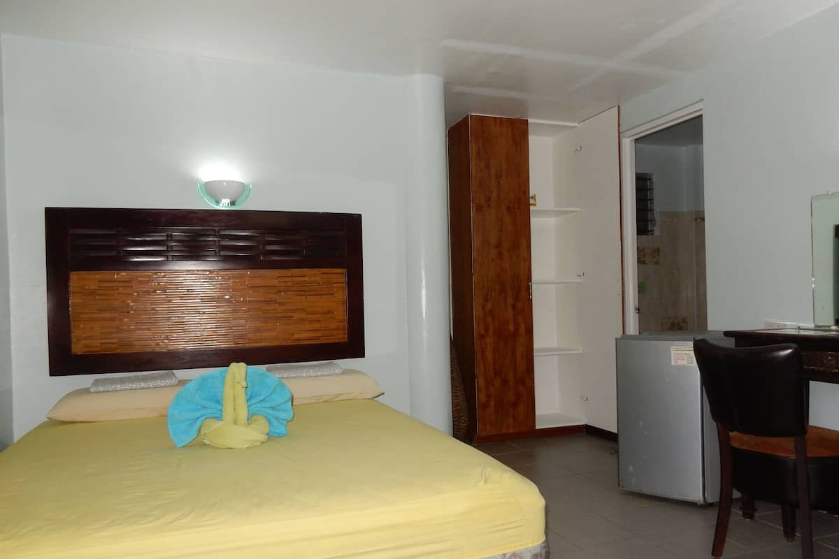 A room with a bed, a desk, and a chair.