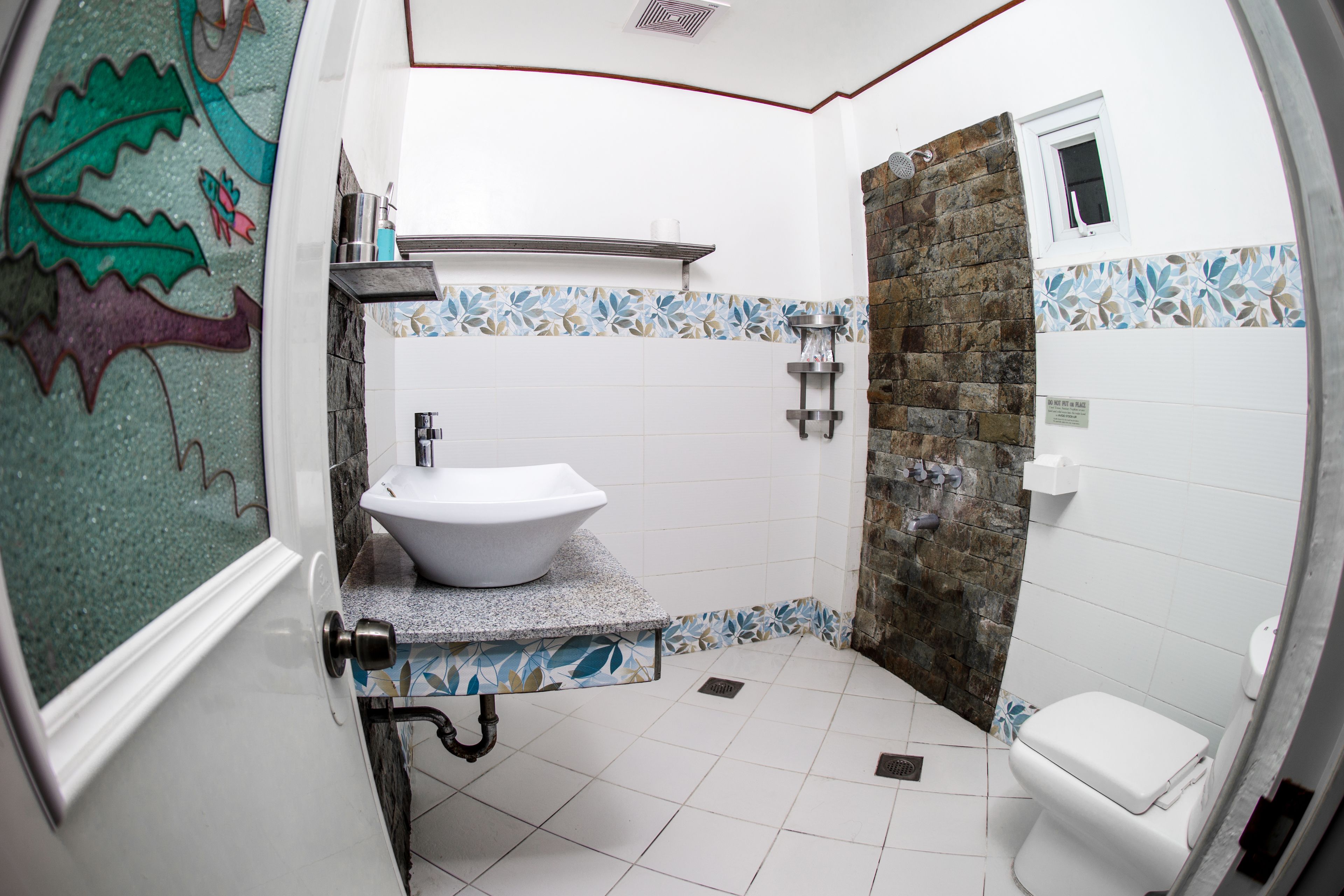 A bathroom with a white sink, a shower area, and a toilet.