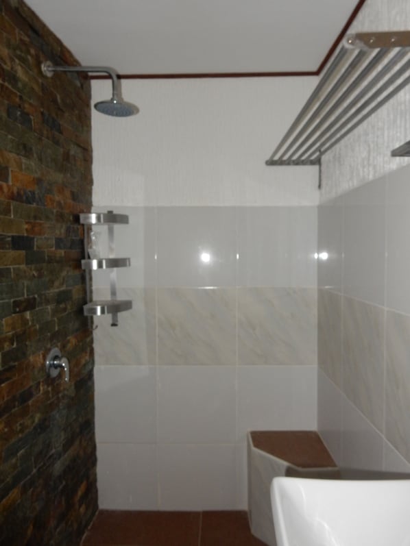 A bathroom with a shower, a toilet, and a sink.