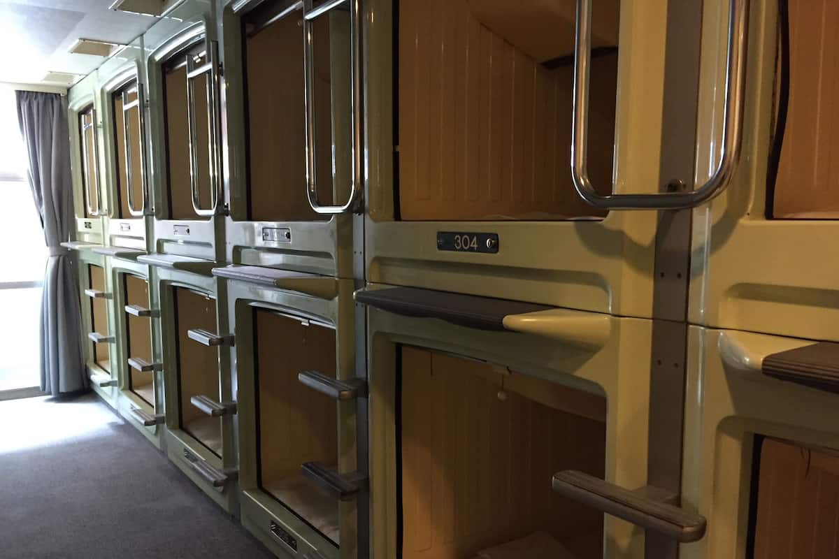A row of train car compartments with metal frames and wooden panels, each with a number plate.