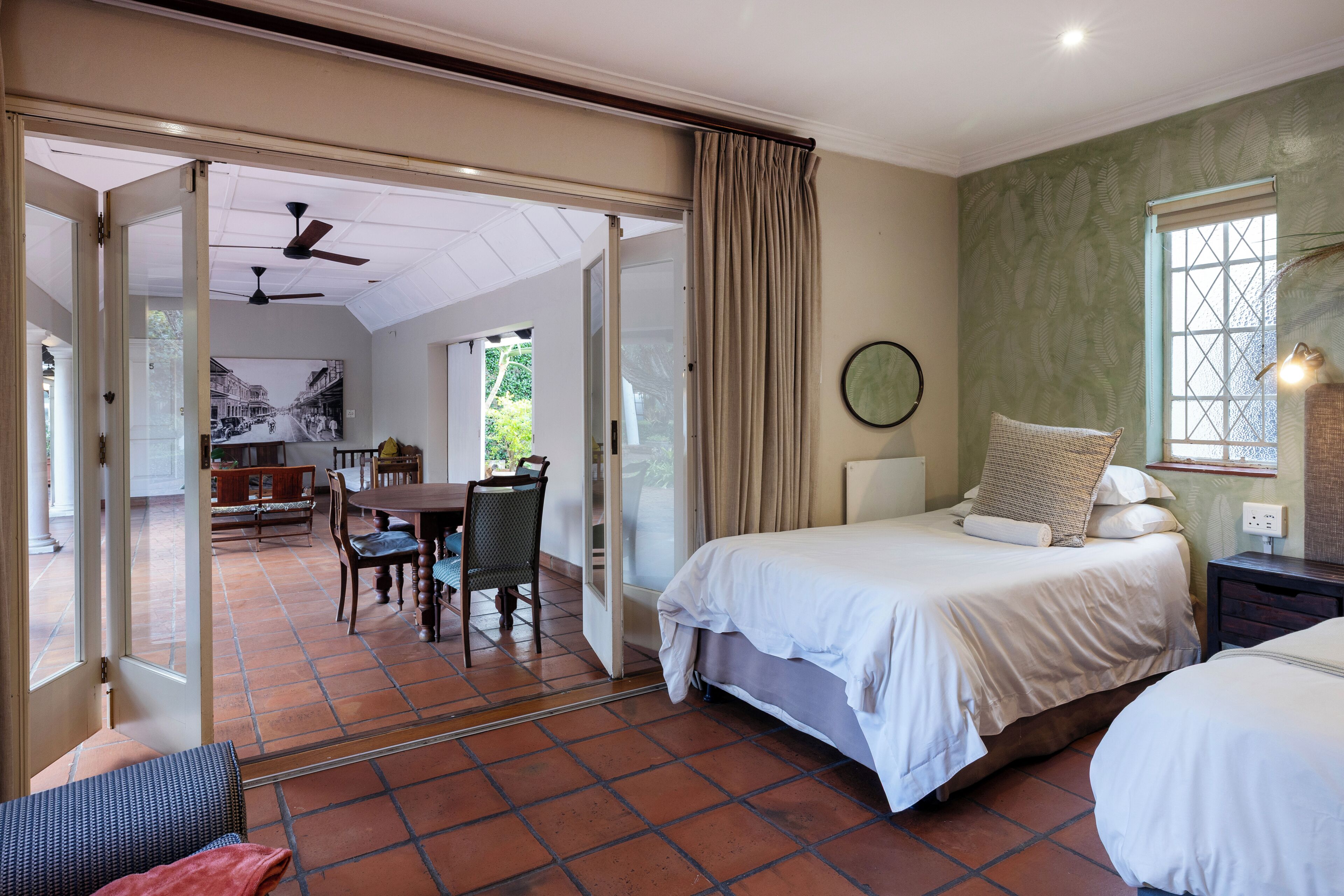 Una habitación de hotel con cama, comedor y vistas a través de una puerta abierta.