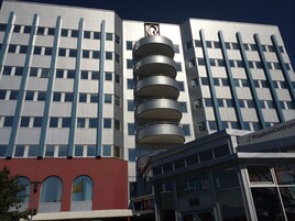 Un edificio moderno con una estructura cilíndrica distintiva, probablemente parte de un complejo más grande.