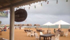 Un restaurante frente al mar con terraza y sombrillas, con vistas al océano.