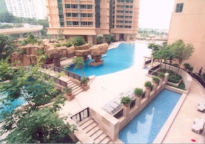 A hotel pool area with a central pool, surrounding rock formations, and lounge chairs. - Winland 800 Hotel (Tsing Yi)