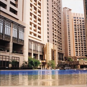 A high-rise residential building with multiple balconies and a swimming pool in the foreground. - Winland 800 Hotel (Tsing Yi)