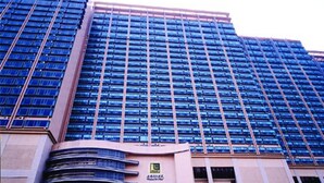 A high-rise building with a modern architectural design, featuring a large number of windows and a prominent curved entrance with signage. - Winland 800 Hotel (Tsing Yi)