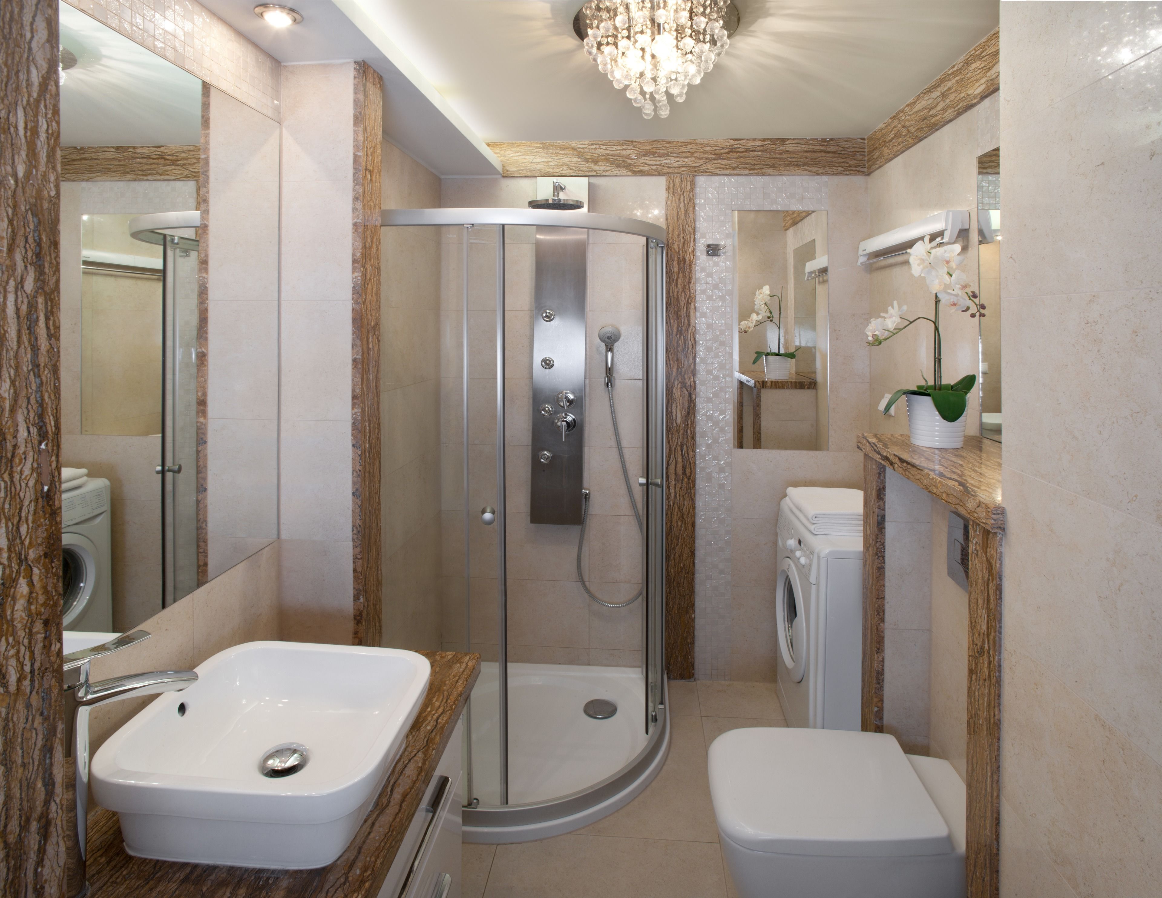 Une salle de bain moderne avec une douche à parois de verre, un lavabo, des toilettes et un miroir.
