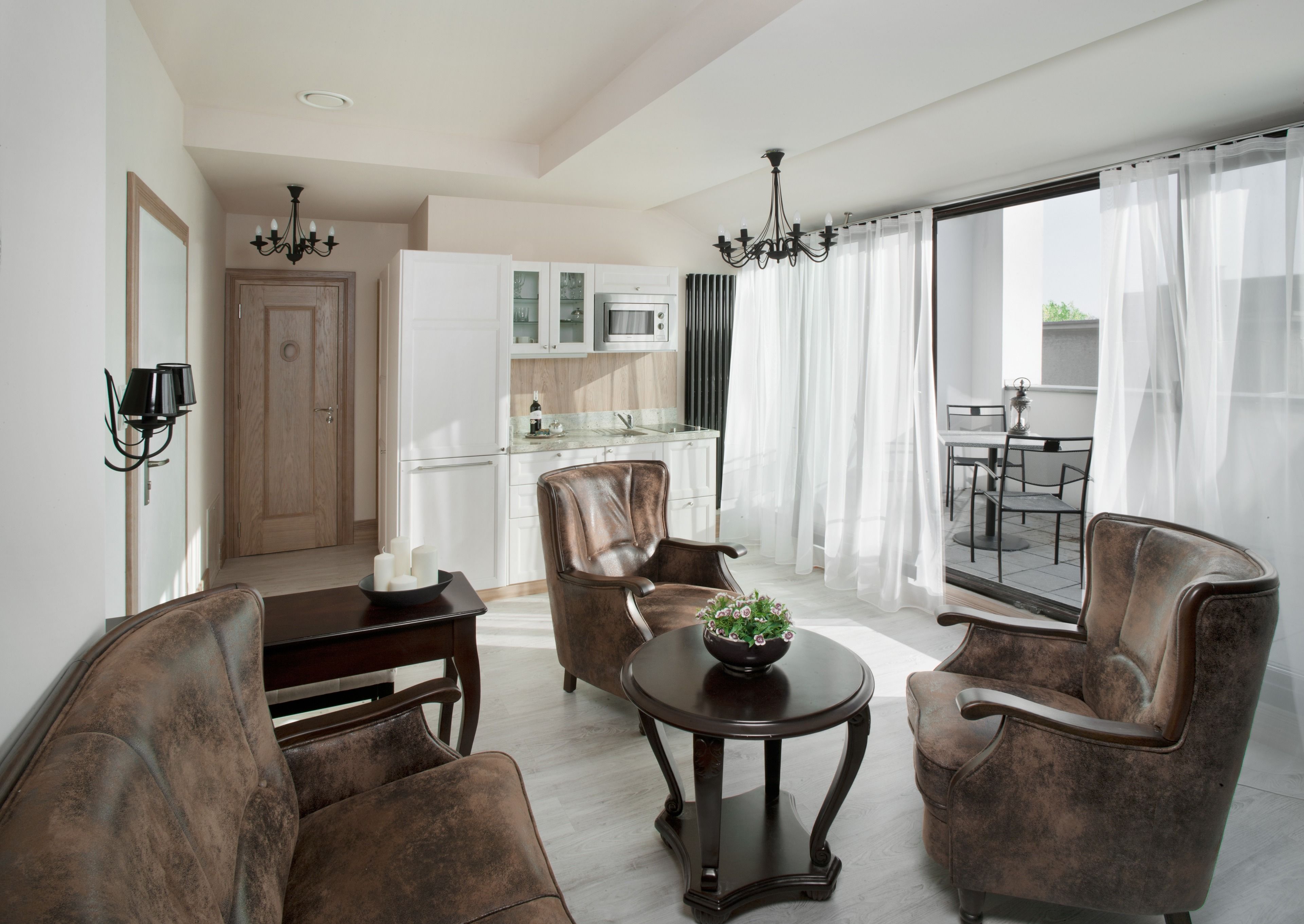 Una sala de estar moderna con comedor, cocina y un balcón con cortinas.
