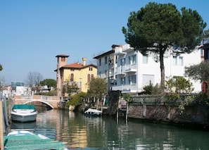 A canal with boats, a bridge, and buildings along the water.